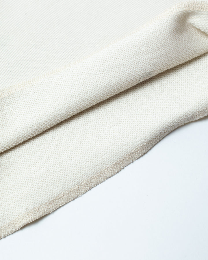 Close up on the inside texture of a flared off white short.