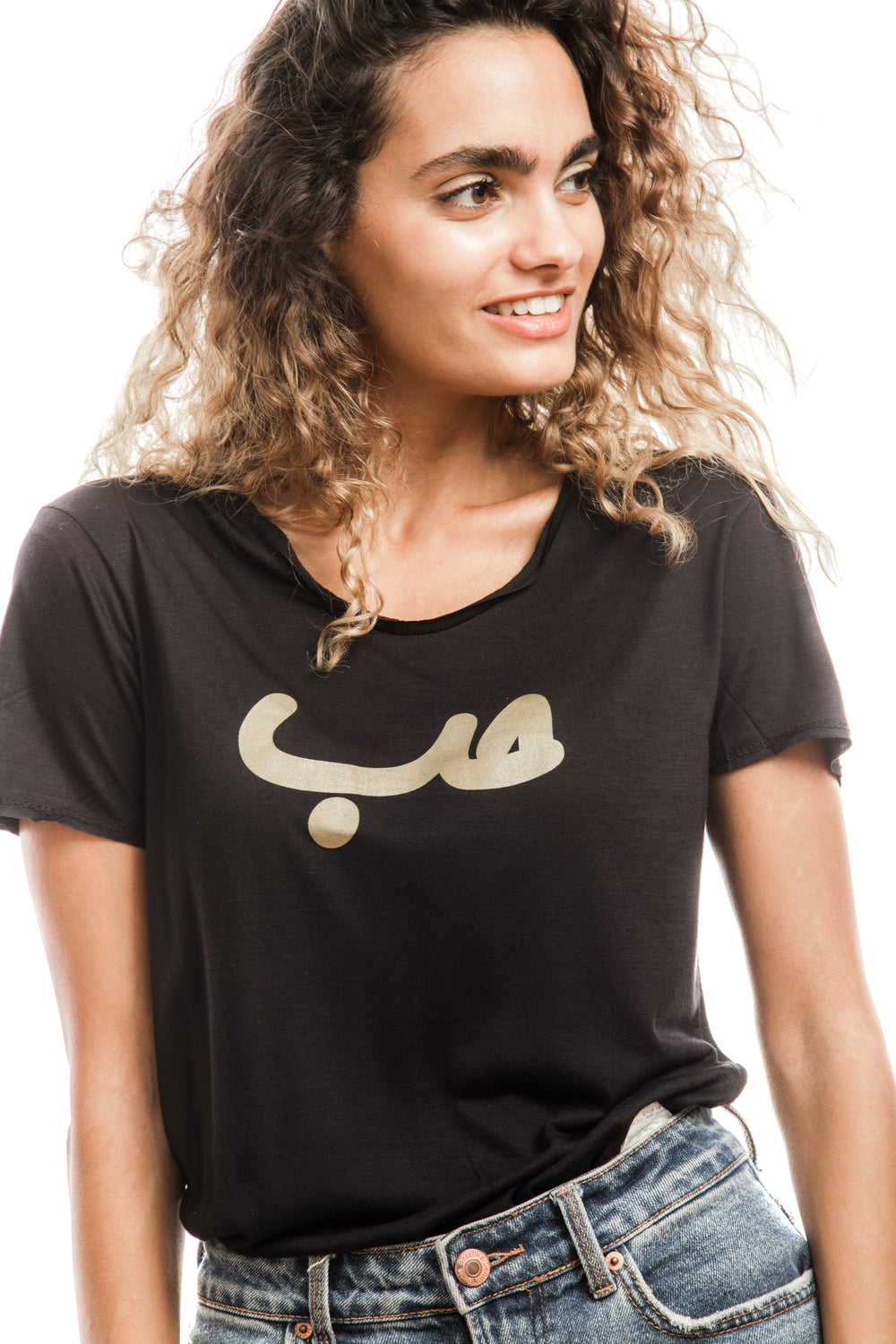 Young adult female wearing black T-shirt with Hobb written in Arabic حب and printed in gold silkscreen in the center of the T-shirt.
