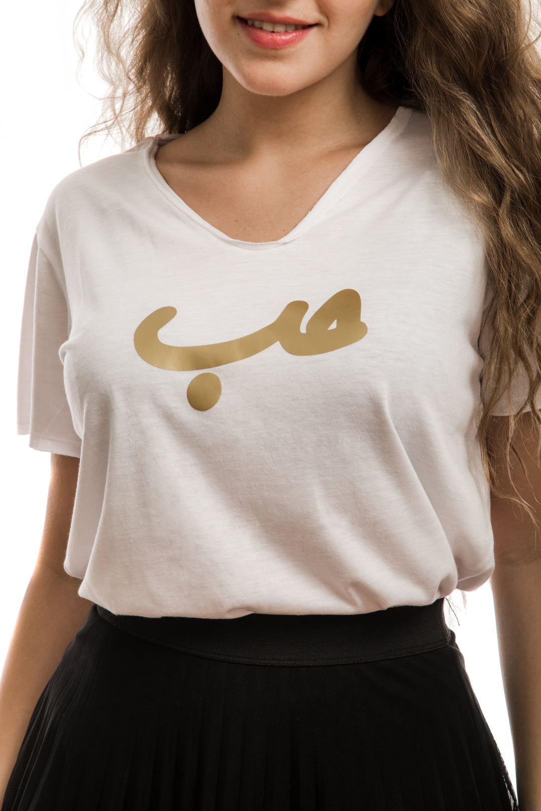 Young adult female wearing white T-shirt with Hobb written in Arabic حب and printed in gold silkscreen in the center of the T-shirt.